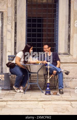 Tunisia. Tunisi Medina. Dar Hamouda Pacha, fine 18. Secolo. Ora un ristorante e una casa da tè. Coppia che si diverte a conversare e una Sheesha. Informale Foto Stock