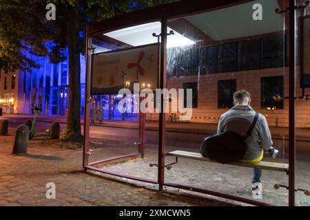 Fermata dell'autobus, edificio illuminato blu del governo del distretto di Muenster, barriera illuminata, a Muenster, Renania settentrionale-Vestfalia, Germania Foto Stock