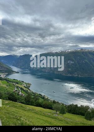 Una vasta distesa d'acqua racchiusa da torreggianti montagne in un giorno coperto Foto Stock