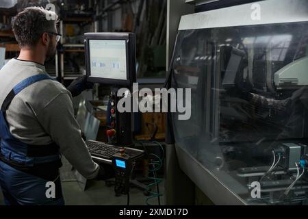 Professional utilizza un computer moderno in produzione Foto Stock