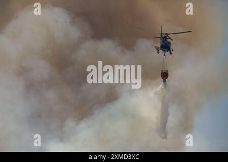 Si vede un elicottero cadere acqua durante l'incendio. Gli incendi in fiamme in Sicilia. Con l'aumento delle temperature e l'espansione della terraferma, l'isola del Mediterraneo soffre della crescente allerta di incendi più vicini alle città e ai centri turistici. Il 20 luglio un incendio si è diffuso da una valle vicina alla periferia di Castellammare del Golfo, nota località turistica. Le fiamme arrivarono vicino alle case, ma i vigili del fuoco e le guardie forestali lo controllarono in tempo. Foto Stock