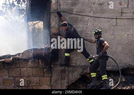 I vigili del fuoco vengono visti durante l'operazione per spegnere l'incendio. Gli incendi in fiamme in Sicilia. Con l'aumento delle temperature e l'espansione della terraferma, l'isola del Mediterraneo soffre della crescente allerta di incendi più vicini alle città e ai centri turistici. Il 20 luglio un incendio si è diffuso da una valle vicina alla periferia di Castellammare del Golfo, nota località turistica. Le fiamme arrivarono vicino alle case, ma i vigili del fuoco e le guardie forestali lo controllarono in tempo. (Foto di Antonio Cascio/SOPA Images/Sipa USA) Foto Stock