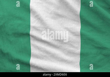 Bandiera della Nigeria raffigurata su tessuto ondulato piegato di vecchio panno primo piano Foto Stock