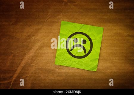 Un biglietto da Libro verde con una faccia triste. Primo piano. Foto Stock