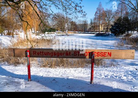 Clima invernale nella regione della Ruhr, Stadtgarten Essen, parco municipale nel centro della città, stagno ghiacciato coperto di neve, Essen, Renania settentrionale-Vestfalia Foto Stock