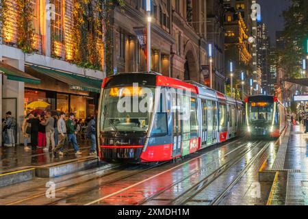 George Street tram sotto la pioggia con riflessi a Sydney, Australia, NSW. Foto Stock