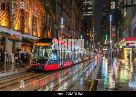 George Street tram sotto la pioggia con riflessi a Sydney, Australia, NSW. Foto Stock