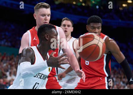 Lille, Francia. 27 luglio 2024. Dennis Schroder (davanti) della Germania passa il pallone durante la partita del gruppo B maschile di pallacanestro tra Germania e Giappone ai Giochi Olimpici di Parigi 2024 a Lille, in Francia, il 27 luglio 2024. Crediti: Meng Dingbo/Xinhua/Alamy Live News Foto Stock