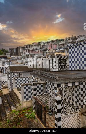 Cimitero, mausolei o grandi cripte decorate con piastrelle, spesso in bianco e nero. Edifici densamente costruiti sotto Un Sunset Cimetière De Morne-à-l'eau Foto Stock