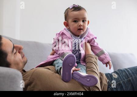 Papà e bambina sdraiati sul divano di casa Foto Stock