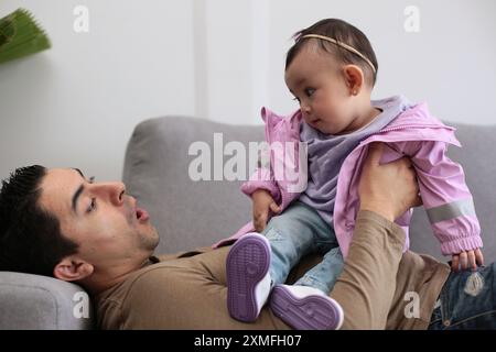 La bambina gioca e gesta con suo padre Foto Stock