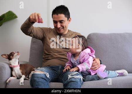 Il giovane padre gioca con il suo cane e il suo bambino Foto Stock