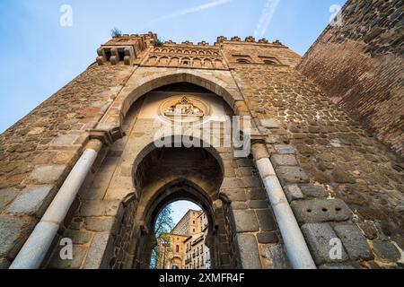 Puerta del Sol, una porta medievale di Toledo, in Spagna, in una giornata di sole. Il medaglione sopra l'arco raffigura l'ordinazione del santo della città Foto Stock