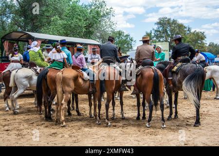 I pellegrini a cavallo si avvicinano attraverso le sabbie del Parco Nazionale di Doñana per raggiungere la loro destinazione nel villaggio di El Rocio ad Almonte alla fine di Foto Stock