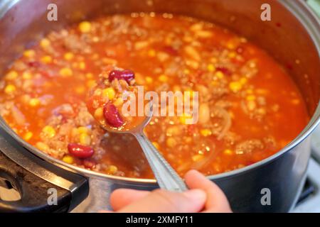 pipì bolliti in una pentola con un pizzico di spezie rosse Foto Stock