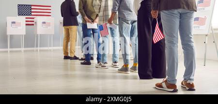 Cittadini americani con bandiere americane in fila al seggio elettorale il giorno delle elezioni Foto Stock