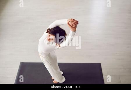 Attraente donna yogi sportiva che si allena e si riscalda, ritratto dall'alto di una bella modella Foto Stock