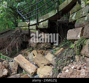 Una breccia sul letto e sul sentiero del canale Lancaster presso l'acquedotto Hollowforth, lavando via pietre e terra dall'acquedotto, il potere della natura. Foto Stock