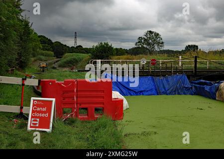 Il canale di Lancaster è arginato da una diga in fibra presso il ponte oscillante Hollowforth a seguito di una breccia nel canale presso l'acquedotto Hollowforth. Foto Stock