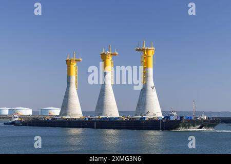 Vista della chiatta S44 trainata dal rimorchiatore per il trasporto di fondazioni a gravità su cui poggiano le turbine eoliche del parco eolico offshore di Fécamp. Foto Stock