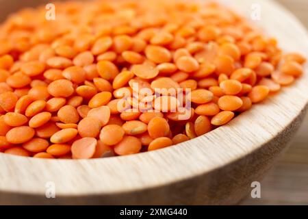 Vista ravvicinata di una ciotola di legno piena di lenticchie rosse. Foto Stock