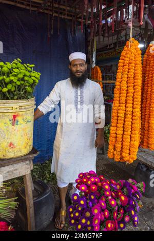 Uomo del Bangladesh che vende fiori di ghirlanda al mercato dei fiori, Divisione di Dacca, Dacca, Bangladesh Foto Stock