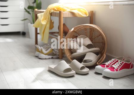 Cestino con pantofole per gli ospiti e scarpe da ginnastica all'ingresso di casa Foto Stock