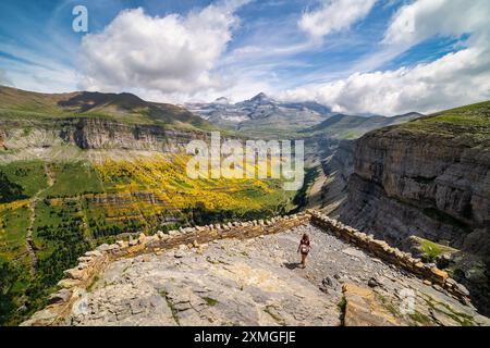 Una donna che guarda su un punto panoramico per vedere l'impressionante valle di Ordesa nei Pirenei spagnoli. Foto Stock