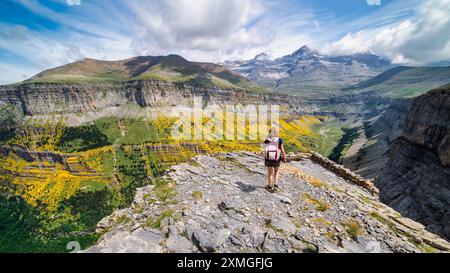 Una donna che guarda su un punto panoramico per vedere l'impressionante valle di Ordesa nei Pirenei spagnoli. Foto Stock