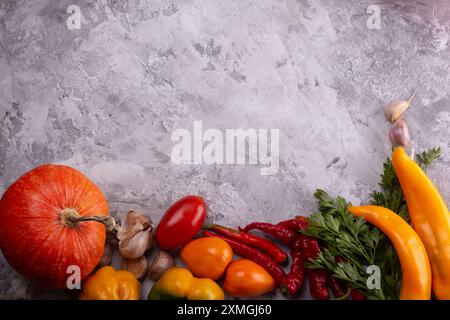 Verdure fresche assortite ed erbe esposte su un elegante sfondo in marmo grigio Foto Stock