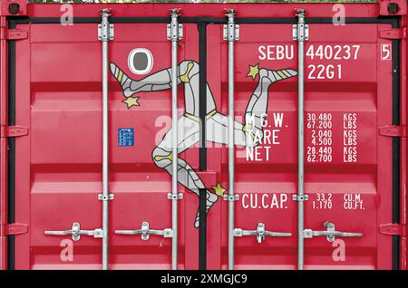 Bandiera dell'Isola di Man raffigurata sulle porte metalliche del container di trasporto merci all'aperto nell'area del molo in primo piano Foto Stock