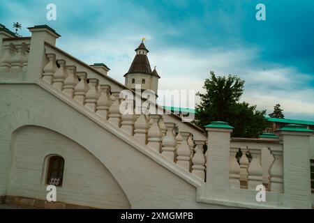 Una scala di pietra bianca conduce a un'antica torre in una fortezza storica, sotto un cielo nuvoloso, che mostra architettura classica e segni storici Foto Stock