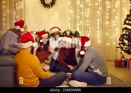 Amici multietnici sorridenti festeggiano il Natale insieme Foto Stock