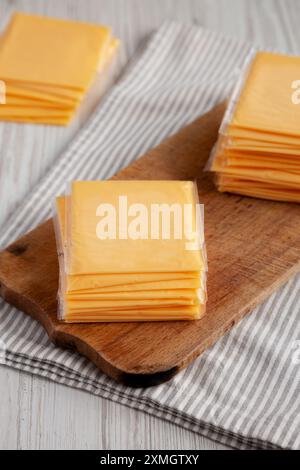 Formaggio americano Cheddar giallo impilato su una tavola di legno, vista laterale. Foto Stock