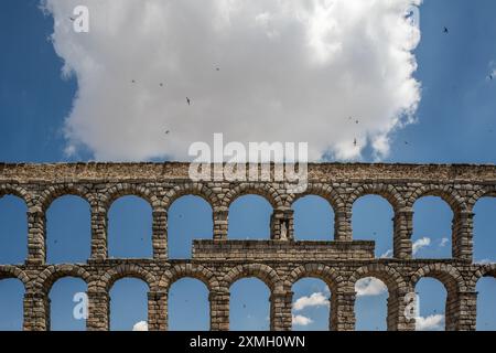 Storico acquedotto romano a Segovia, Castilla y Leon, Spagna. Con archi in pietra e un cielo blu con nuvole. Foto Stock