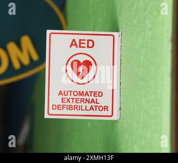 Logo del defibrillatore elettrico su un cartello in un ambiente urbano, che indica la presenza vicina di un dispositivo semiautomatico esterno, Foto Stock