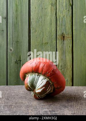 Zucca turbana o zucca turbana su un vecchio tavolo di legno con sfondo verde Foto Stock