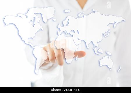 Una donna punta il dito su una mappa del mondo Foto Stock
