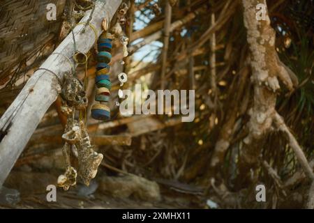 Pecatu, Bali, Indonesia - 15 luglio 2024: Le decorazioni etniche fatte a mano, fatte con conchiglie e oggetti riciclati, sono appese e ondeggianti al vento in un Foto Stock