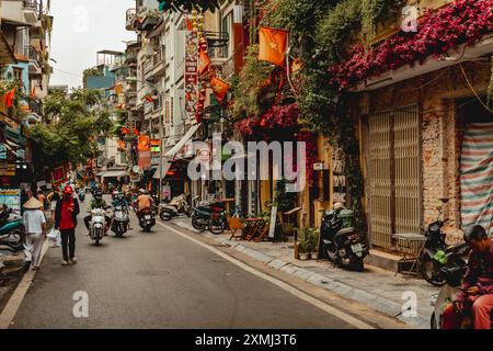 Scena di strada ad Hanoi con traffico scooter Foto Stock