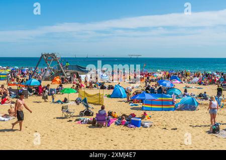 East Cliff Beach, Bournemouth, Regno Unito - 28 luglio 2024: Bagnanti sulla spiaggia sabbiosa godendosi il caldo. Foto Stock