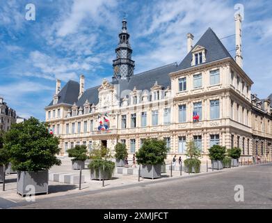 reims, francia, 18 luglio 2024: le persone camminano di fronte all'hotel de ville nella città francese di reims sotto il cielo estivo blu Foto Stock