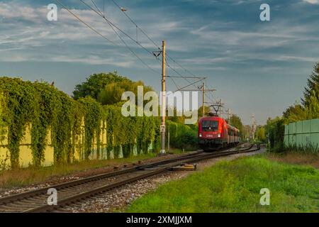 Locomotiva elettrica rossa con treno passeggeri dall'Austria a Ceske Budejovice CZ 07 27 2024 Foto Stock