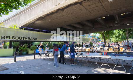 Il cinema BFI Southbank e le bancarelle di vendita di libri sotto il Waterloo Bridge in una giornata di sole. Londra - 28 luglio 2024 Foto Stock