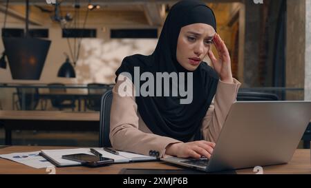 Triste lavoratrice musulmana donna d'affari islamica in hijab turbata errore di progetto online uomo arabo uomo d'affari capo allenatore venire aiutare tirocinante risolvere Foto Stock