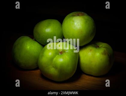 Mazzo di cinque mele verdi (Granny Smith, Golden, Pippin, Crispin) isolate su un tavolo di legno Foto Stock