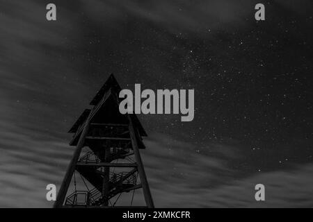 Symbolbild Aussichtsturm, Nachtaufnahme, Sterne, bewölkter Himmel, silhouette, Landschaft, Dunkelheit, Holzstruktur, Langzeitbelichtung, Natur, Nachthimmel, Lichter der Stadt, ruhige Atmosphäre, Sterne und Wolken, Erkundung, Schwarzwald, Schauinsland *** Torre di osservazione immagine simbolo, ripresa notturna, stelle, cielo nuvoloso, silhouette, paesaggio, oscurità, struttura in legno, esposizione prolungata, natura, cielo notturno, luci della città, atmosfera tranquilla, stelle e nuvole, esplorazione, foresta Nera, Schauinsland Copyright: xArnexAmbergx Foto Stock