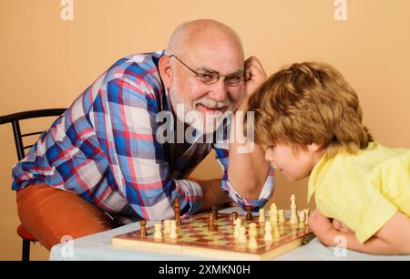 Gioco di scacchi. Nonno e nipote giocano a scacchi a casa. Bambino che pensa alla prossima mossa nel gioco degli scacchi. Sviluppo di logica e strategi Foto Stock