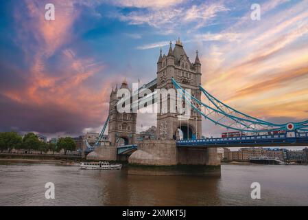 Tower Bridge al tramonto con barca sul Tamigi a Londra, Regno Unito Foto Stock