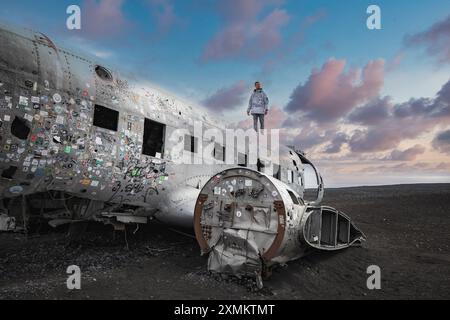 Persona in piedi sul relitto Douglas DC-3 della US Navy a Solheimasandur Beach, Islanda Foto Stock